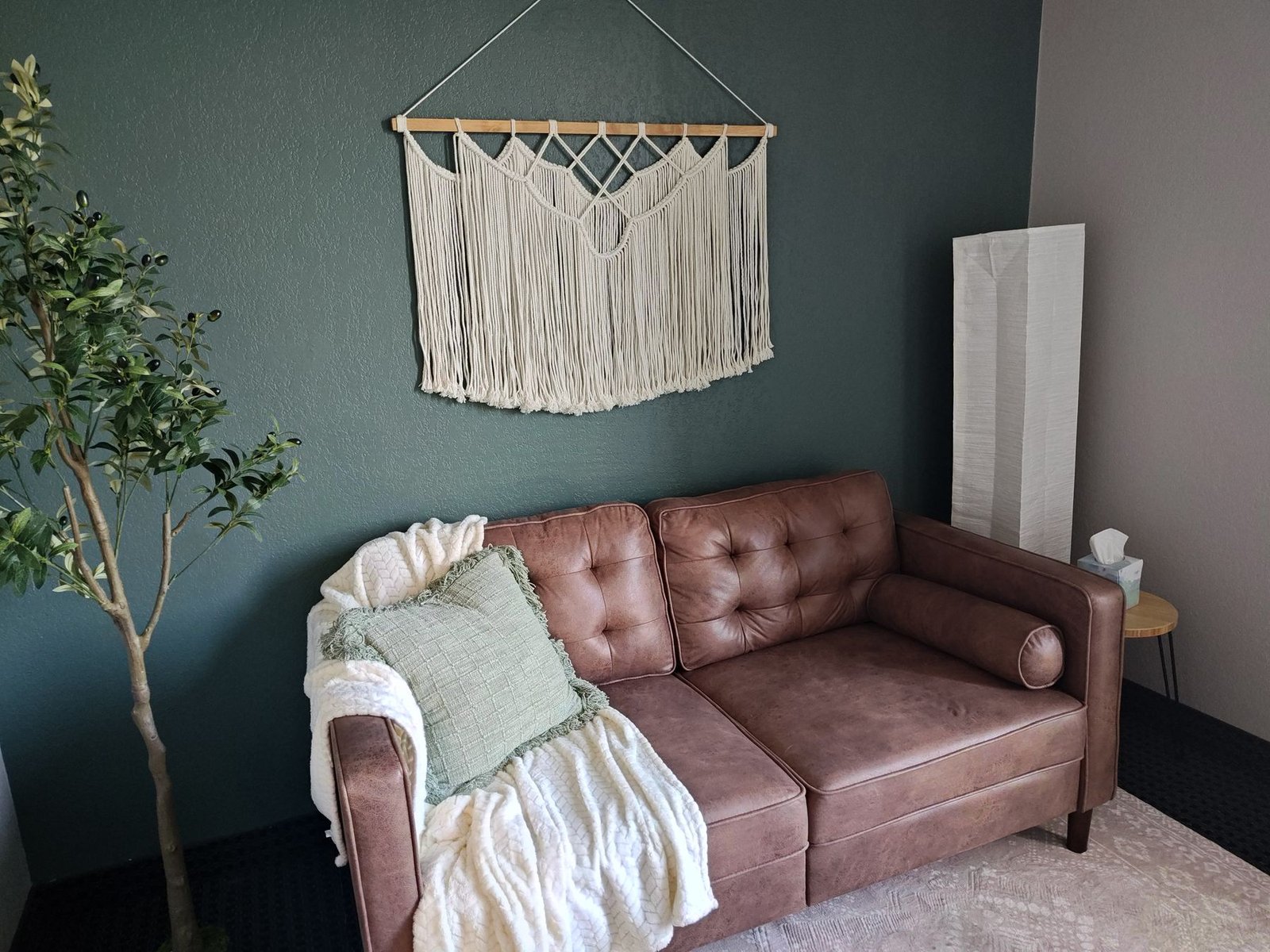 A comfortable leather sofa with a soft throw in the Arbor Creek waiting room