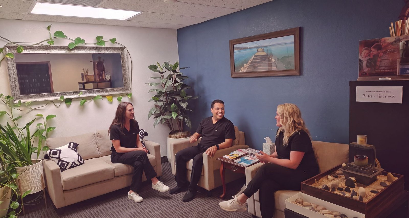 Amy Abbott, Dr. Tim Bhakta and Kerri Lindsay talking together in the Arbor Creek waiting room