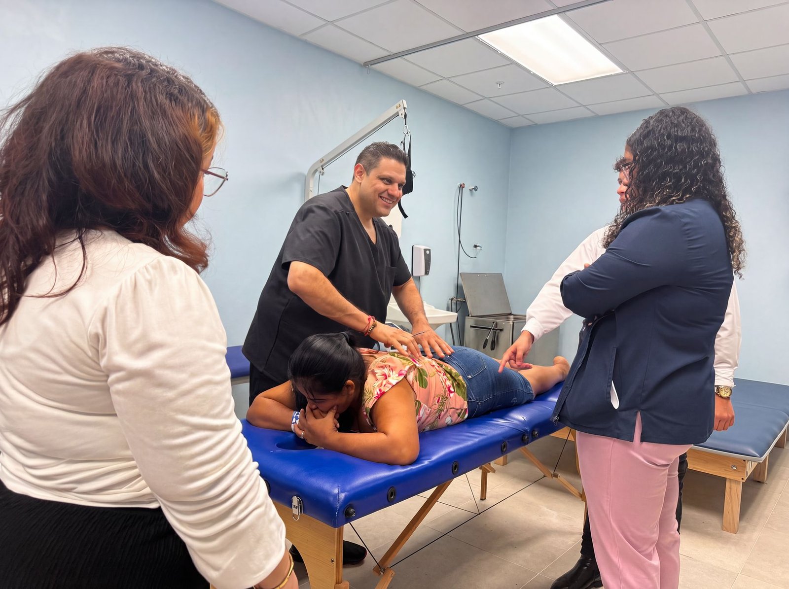 Dr. Tim Bhakta assessing a patient’s back on a treatment table