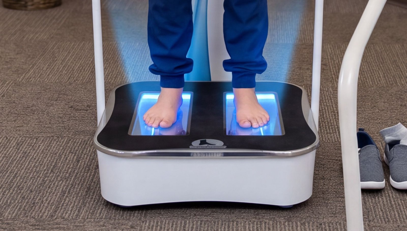 Bare feet on a lit 3D foot scanner plate during a Foot Levelers scan